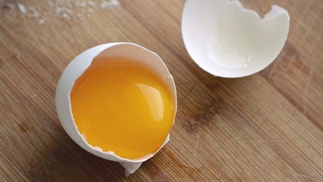 Un huevo abierto y su yema.